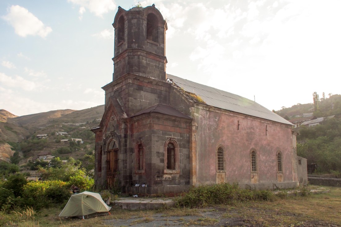 Our tent, parked in front of an abandoned church in an abandoned town.